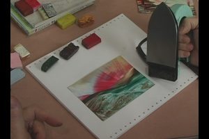 Az enkausztika meleg technikájának eszközei, a színes viasz rudak és a vasaló szerű melegítő eszköz 
