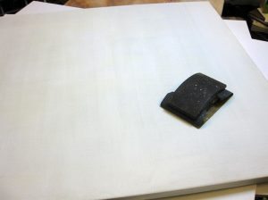 Egy életlen késsel, spaklival, vagy akár egy vonalzóval, lehúzzuk a felesleges anyagot a felületről, ha vásznat alapozunk, akkor közben passzírozzuk is a vászon szemek közé az anyagot. Ugyanúgy, ahogy az enyvezésnél leírtuk. 